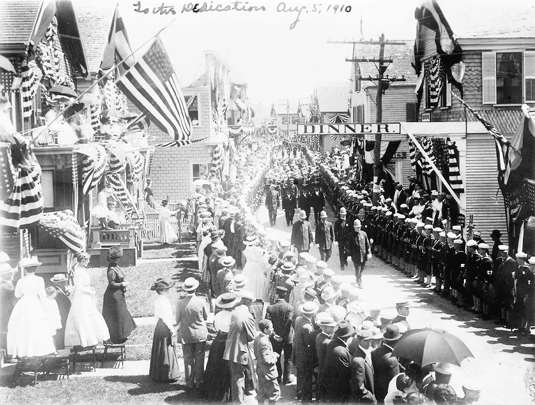 The presidential parade for the Pilgrim Monument dedication on August. 5, 1910. The image shows the parade moving west down Commercial Street near the corner of Ryder Street.